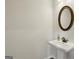 Elegant powder room with a round mirror and pedestal sink at 375 Crider Ct, Woodstock, GA 30188