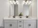 Bathroom with double sinks, white cabinets, marble countertops, and modern fixtures at 375 Crider Ct, Woodstock, GA 30188