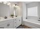 Well-lit bathroom includes a double vanity, soaking tub, and contemporary fixtures at 375 Crider Ct, Woodstock, GA 30188