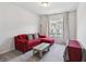 Cozy sitting area with red couch, wooden coffee table, and window views at 375 Crider Ct, Woodstock, GA 30188
