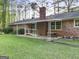 Exterior view of brick home with back patio, showing ramp access and manicured lawn at 242 Hickory Rd, Fayetteville, GA 30214