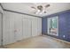 Charming bedroom featuring blue wallpaper, ceiling fan and a window view at 242 Hickory Rd, Fayetteville, GA 30214