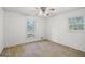 Bright bedroom with neutral walls, two windows, and plush carpet flooring at 242 Hickory Rd, Fayetteville, GA 30214
