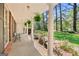 Inviting front porch with brick floor, decorative columns, and lush landscaping leading to the front lawn at 242 Hickory Rd, Fayetteville, GA 30214