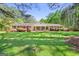Charming brick ranch home featuring a lush, green lawn and mature landscaping at 242 Hickory Rd, Fayetteville, GA 30214
