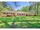 Charming brick ranch home featuring a lush, green lawn and mature landscaping at 242 Hickory Rd, Fayetteville, GA 30214