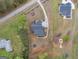 Aerial view of a house with a long drive, dark roof, lawn, and wooded lot at 319 S Mount Carmel Rd, Mcdonough, GA 30253