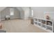 Upstairs bonus room with plush neutral carpet, built-in shelves and natural lighting at 319 S Mount Carmel Rd, Mcdonough, GA 30253