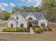 Charming two-story white farmhouse with brick accents and professionally landscaped front yard at 319 S Mount Carmel Rd, Mcdonough, GA 30253