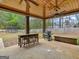 Outdoor patio features a ceiling fan, BBQ, trampoline, and dark wood columns and furniture at 319 S Mount Carmel Rd, Mcdonough, GA 30253