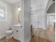 Well-lit powder room with shiplap wall, wood-look floors, and stylish vanity at 319 S Mount Carmel Rd, Mcdonough, GA 30253
