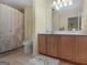 Functional bathroom with a shower-tub combo, neutral tile, and a wooden vanity at 307 Gladstone Dr, Mcdonough, GA 30253