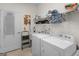 Bright laundry room includes a sink, washer, dryer, storage shelves, and an ironing board for added convenience at 307 Gladstone Dr, Mcdonough, GA 30253