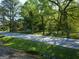 A pleasant street view featuring mature trees, and a glimpse of charming homes in a serene residential area at 174 E Broad St, Fairburn, GA 30213