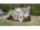 Aerial view of two-story home with lush landscaping, a walkway, and a cozy front porch at 225 Briarsweet Way, Fayetteville, GA 30215