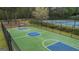 Basketball court with a green surface and blue key and center circle; bordered by black fencing at 225 Briarsweet Way, Fayetteville, GA 30215
