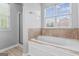 Spa-like bathroom featuring a soaking tub with tile surround and a separate glass-enclosed shower at 225 Briarsweet Way, Fayetteville, GA 30215
