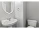 Powder room features a pedestal sink, oval mirror, and toilet at 225 Briarsweet Way, Fayetteville, GA 30215