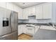 Well-lit kitchen with white cabinetry, granite countertops, and modern appliances at 225 Briarsweet Way, Fayetteville, GA 30215