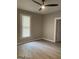 Bedroom featuring a ceiling fan, wood-look floors, and a bright window at 116 Stewart Ave, Jonesboro, GA 30236