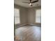 Neutral bedroom with modern ceiling fan, gray walls and wood-look floors and two windows at 116 Stewart Ave, Jonesboro, GA 30236
