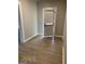 Neutral hallway with wood-look floors, leading to the exterior door with a window covering at 116 Stewart Ave, Jonesboro, GA 30236