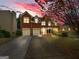 Charming brick two-story home with attached two car garage and well-manicured front yard at sunset at 3195 Vickery Ne Dr, Marietta, GA 30066