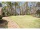 Lush backyard with stone path, inground pool, and mature trees for privacy at 110 Kylemore Pass, Tyrone, GA 30290