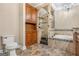 Bathroom featuring a glass shower, tile surround soaking tub, custom cabinets and tile floors, and chandelier at 110 Kylemore Pass, Tyrone, GA 30290