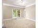 Bright bedroom with neutral carpet, large windows, and a ceiling fan, providing a comfortable and airy atmosphere at 110 Kylemore Pass, Tyrone, GA 30290