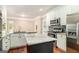 Bright kitchen featuring white cabinets, a kitchen island, granite countertops, tile backsplash, and stainless steel appliances at 110 Kylemore Pass, Tyrone, GA 30290