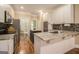 Bright kitchen featuring white cabinets, a kitchen island, granite countertops, tile backsplash, and stainless steel appliances at 110 Kylemore Pass, Tyrone, GA 30290