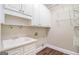 Laundry room featuring white cabinets and a sink at 110 Kylemore Pass, Tyrone, GA 30290
