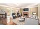 Stylishly decorated living room with stone fireplace, hardwood floors, and comfortable seating at 110 Kylemore Pass, Tyrone, GA 30290