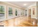 Bright living room featuring hardwood floors, large windows, and double doors to the backyard at 110 Kylemore Pass, Tyrone, GA 30290