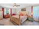 Spacious bedroom featuring a ceiling fan, neutral walls, a decorative sign, and large windows at 140 Crimson Rdg, Tyrone, GA 30290