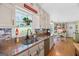 Well-lit kitchen featuring custom cabinets, granite counters, and views to the breakfast area at 140 Crimson Rdg, Tyrone, GA 30290