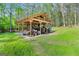 View of the outbuilding structure holding a tractor, trailer, and other farm equipment at 140 Crimson Rdg, Tyrone, GA 30290