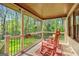 Cozy covered porch featuring rocking chairs and a serene view of the surrounding greenery at 140 Crimson Rdg, Tyrone, GA 30290
