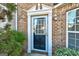 Close-up view of the front door of a brick townhome with white trim and well-kept landscaping at 11419 South Grove Dr, Hampton, GA 30228