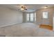 Bright living room with neutral walls, plush carpet, ceiling fan, and large window bay allowing natural light at 11419 South Grove Dr, Hampton, GA 30228