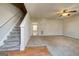 Open living room with a carpeted floor, ceiling fan, staircase, and natural light at 11419 South Grove Dr, Hampton, GA 30228