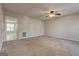 Bright living room with neutral carpet and a ceiling fan, flowing into another room at 11419 South Grove Dr, Hampton, GA 30228