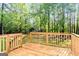 Wooden deck with rail and stairs in a wooded backyard setting at 653 Locust Rd, Locust Grove, GA 30248