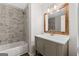 Bathroom featuring tub with marble tile surround and wood-framed mirror at 653 Locust Rd, Locust Grove, GA 30248