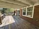 Wooden deck offers a relaxing outdoor space with brick exterior, multiple windows, and view of surrounding greenery at 183 Busbin Rd, Fayetteville, GA 30215