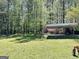 Picturesque backyard featuring a storage shed surrounded by vibrant flowers and lush trees at 183 Busbin Rd, Fayetteville, GA 30215