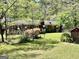 A spacious backyard with a lush green lawn, blooming flowers, and a charming brick shed at 183 Busbin Rd, Fayetteville, GA 30215