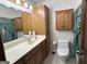 Traditional bathroom features wood cabinets, shower curtain and patterned wallpaper at 183 Busbin Rd, Fayetteville, GA 30215