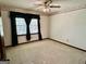 Bedroom with neutral carpet, ceiling fan, and a large window with dark curtains at 183 Busbin Rd, Fayetteville, GA 30215